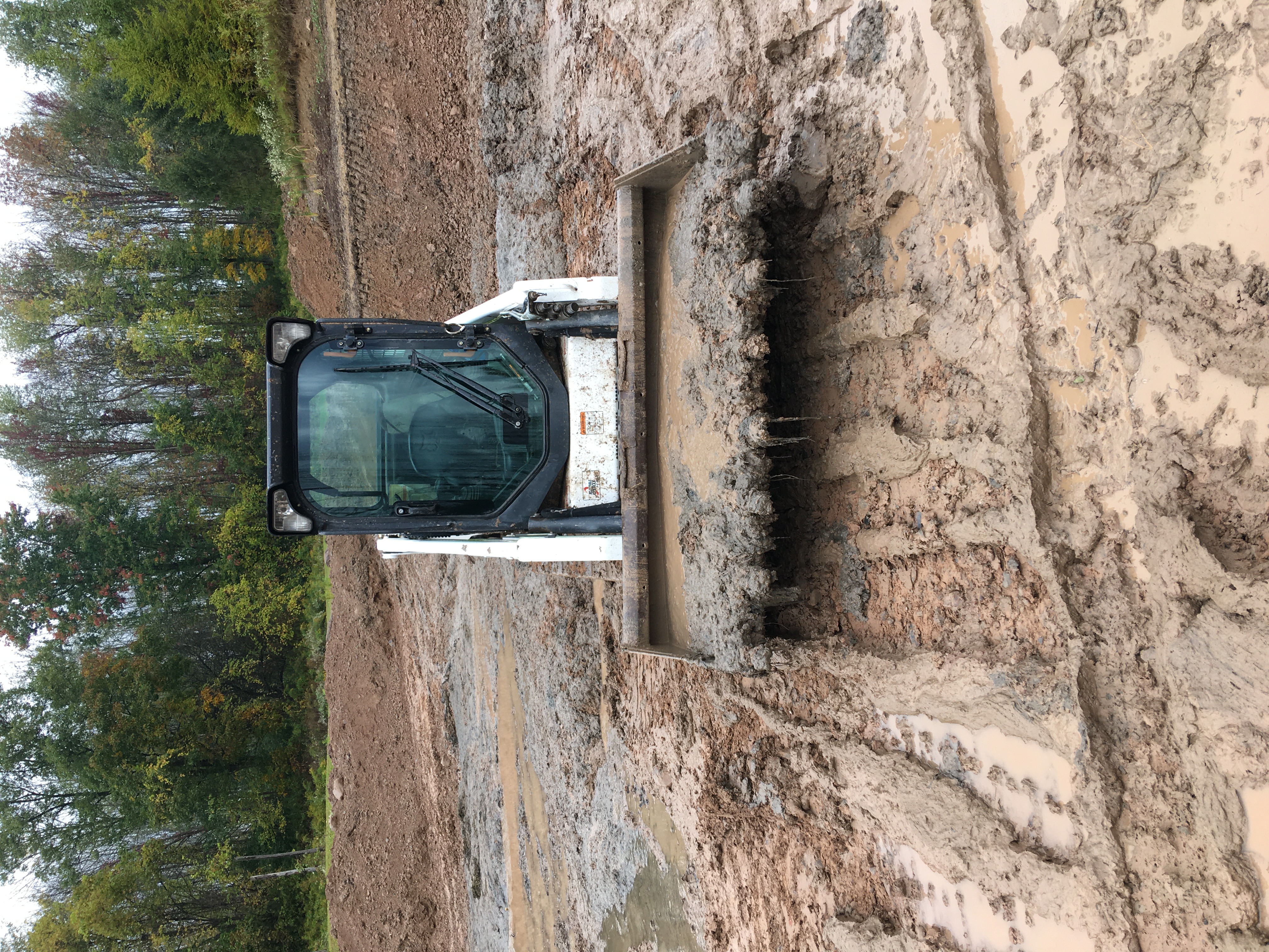 Track loader digging deep mud during pond repair work in Arkansas